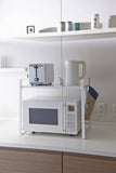 Counter organizer by Yamazaki sitting atop a microwave in a kitchen