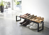 Yamazaki's Simple black shoe rack filled with shoes next to the door
