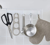 Close up of kitchen utensils and oven mitt hanging from 5-hook attachment on the Grid Panel Organizer 